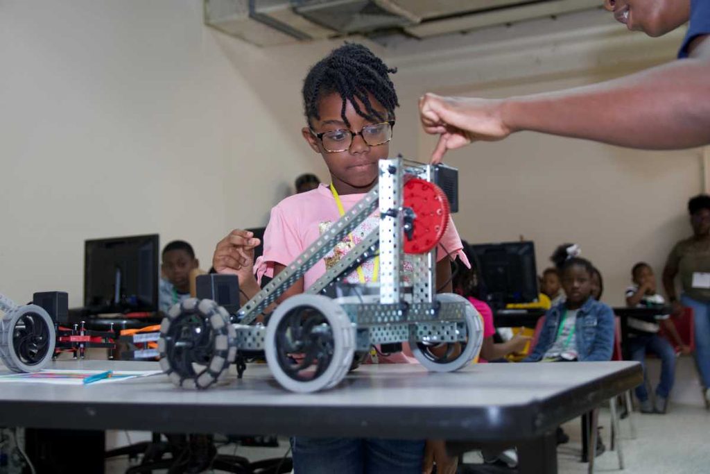 Campers work together with a robotics kit.